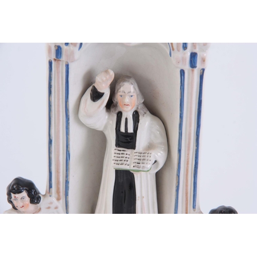 102 - A 19TH CENTURY STAFFORDSHIRE FLATBACK CLOCK TOWER FIGURE with John Wesley 28cm high by 14cm wide