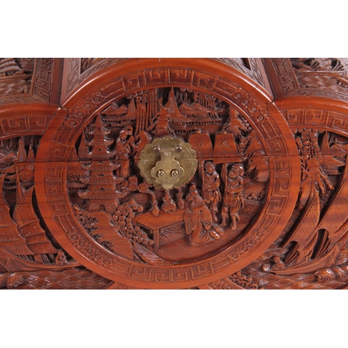 126 - A CARVED CHINESE HARDWOOD SHAPED BLANKET BOX decorated with figures amongst trees and galleons 102cm... 