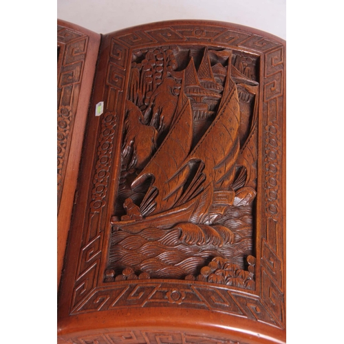 126 - A CARVED CHINESE HARDWOOD SHAPED BLANKET BOX decorated with figures amongst trees and galleons 102cm... 