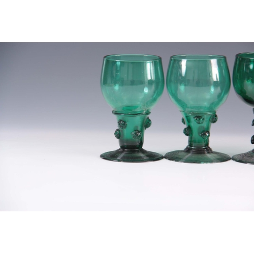 13 - A MATCHED SET OF FOUR 19TH CENTURY BRISTOL GREEN WINE GLASSES with rounded bowls continuing downward... 