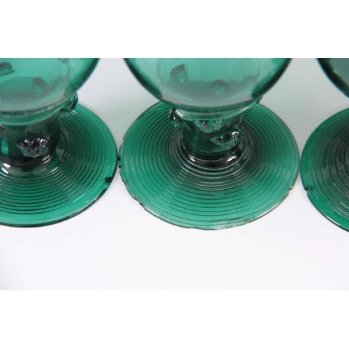 13 - A MATCHED SET OF FOUR 19TH CENTURY BRISTOL GREEN WINE GLASSES with rounded bowls continuing downward... 