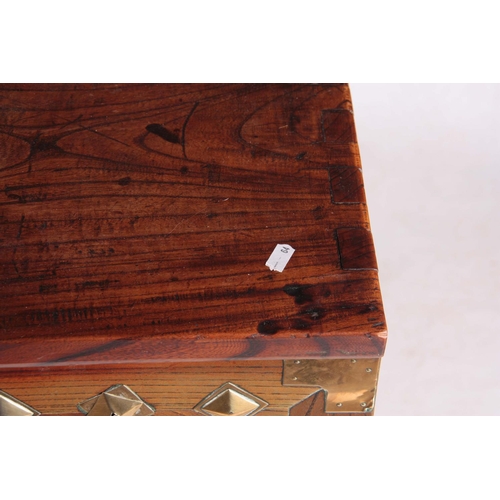 130 - AN 18TH CENTURY CHINESE ELM CHEST with brass mounted decorated front and hinged lock plate; standing... 