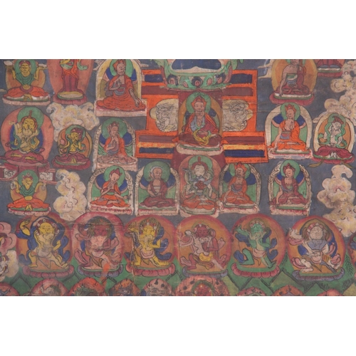 132 - AN INTERESTING LARGE INDIAN OIL ON CANVAS depicting Gods and buddhas - glazed modern frame 82cm high... 