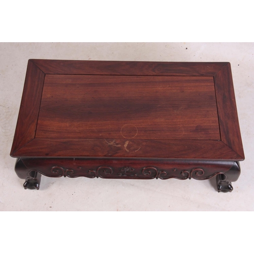 138 - A 19TH CENTURY CHINESE HARDWOOD LOW OCCASIONAL TABLE with panelled top and shaped scroll carved base... 