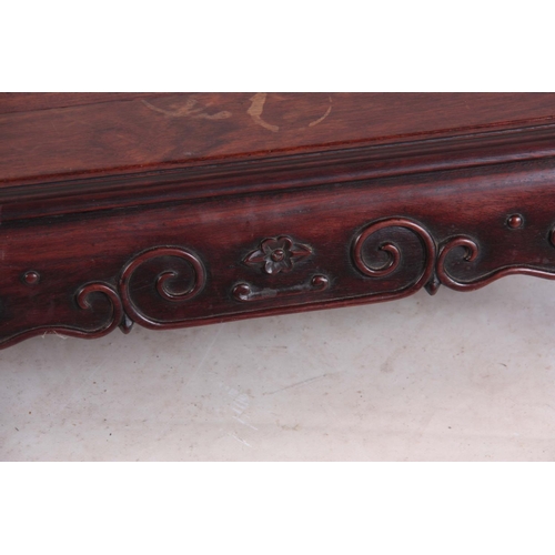 138 - A 19TH CENTURY CHINESE HARDWOOD LOW OCCASIONAL TABLE with panelled top and shaped scroll carved base... 