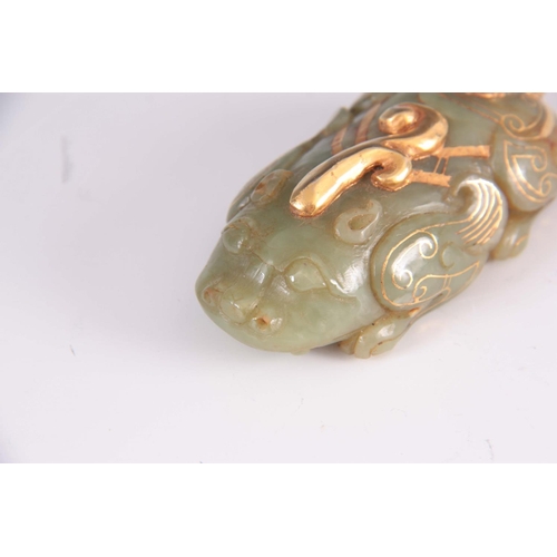 159 - A CHINESE JADE AND GILT SCULPTURE modelled as a crouching Foo dog 8.5cm long