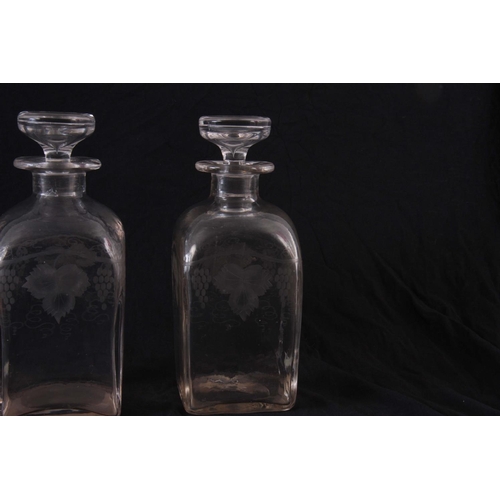 18 - A PAIR OF GEORGIAN SQUARE GLASS WHEEL ENGRAVED DECANTERS, decorated with grapes and vines, stoppers ... 