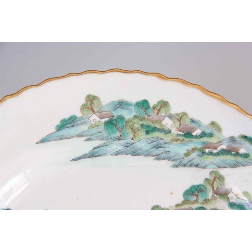 182 - A CHINESE JIAQING PERIOD FAMILLE VERTE PORCELAIN LANDSCAPE PLATE with gilded scalloped rim, the back... 