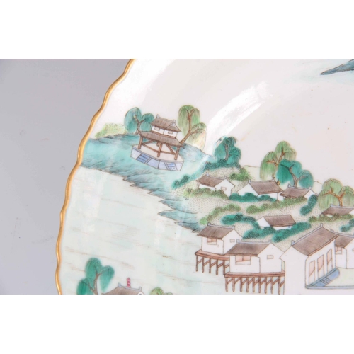 182 - A CHINESE JIAQING PERIOD FAMILLE VERTE PORCELAIN LANDSCAPE PLATE with gilded scalloped rim, the back... 