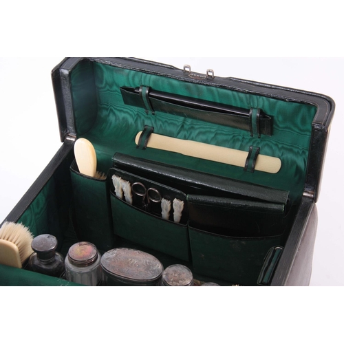 214 - A GREEN LEATHER FITTED VANITY CASE BY DREW & SONS, LONDON complete with silver mounted bottles and i... 