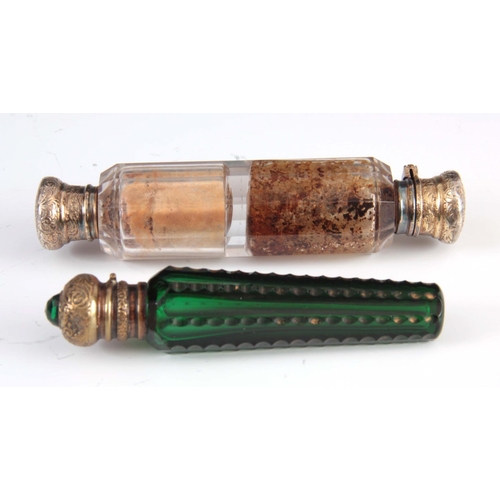 23 - A DOUBLE ENDED FACETED GLASS SCENT BOTTLE and a green cut glass scent bottle with jeweled lid, talle... 