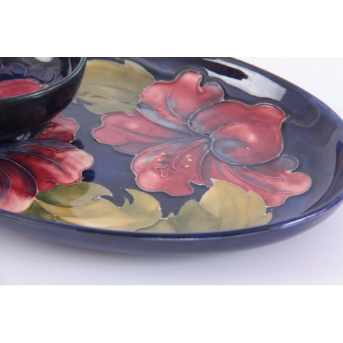 41 - A MID 20TH CENTURY WALTER MOORCROFT OVAL HIBISCUS PLATE on a blue ground  23cm by 15.5cmTOGETHER WIT... 