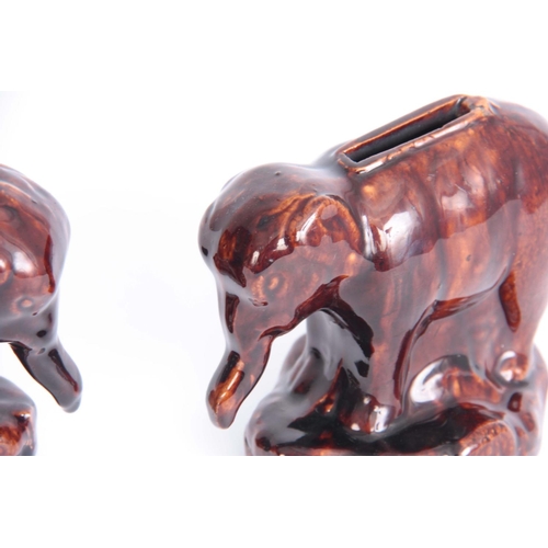 63 - A PAIR OF 19TH CENTURY TREACLE GLAZED POTTERY ELEPHANT MONEY BOXES possibly Rockingham 10cm high by ... 