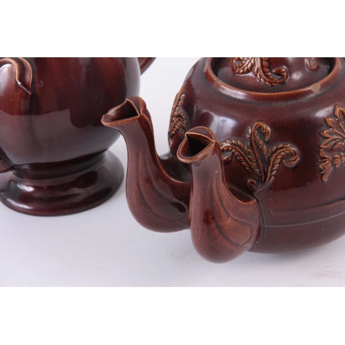 66 - TWO  UNUSUAL 19TH CENTURY TEAPOTS, one being an oversized double spouted treacle glazed decorated wi... 