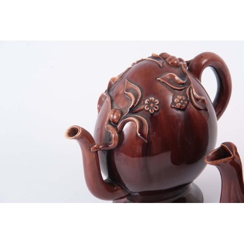 66 - TWO  UNUSUAL 19TH CENTURY TEAPOTS, one being an oversized double spouted treacle glazed decorated wi... 