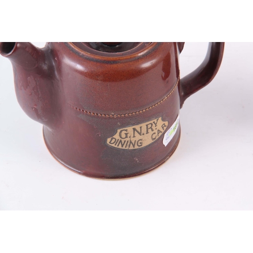 72 - AN EARLY 20TH CENTURY GNR, RAILWAY DINING CAR TEAPOT, having a treacle glaze 10cm high by 15cm wide,... 