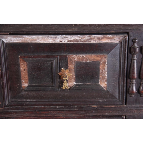 1130 - A LATE 17TH CENTURY GEOMETRIC MOULDED OAK CHEST ON STAND having three graduated drawers with side ru... 