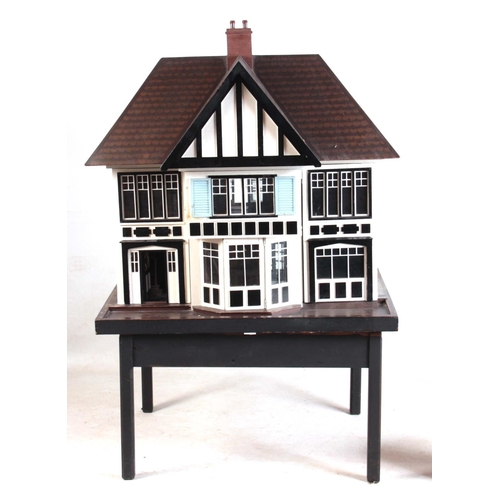 1131 - A LARGE EDWARDIAN DOLLS HOUSE fully fitted with furniture - on a stand 101cm wide 78cm deep