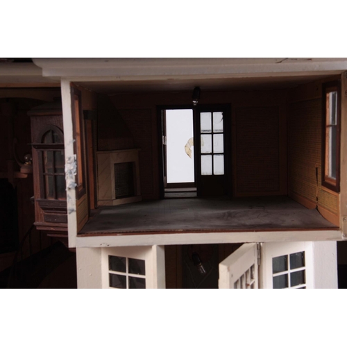 1131 - A LARGE EDWARDIAN DOLLS HOUSE fully fitted with furniture - on a stand 101cm wide 78cm deep