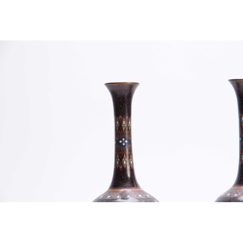 135 - A PAIR OF EARLY 20TH CENTURY CLOISONNE VASES decorated with birds and geometric designs 25cm high.