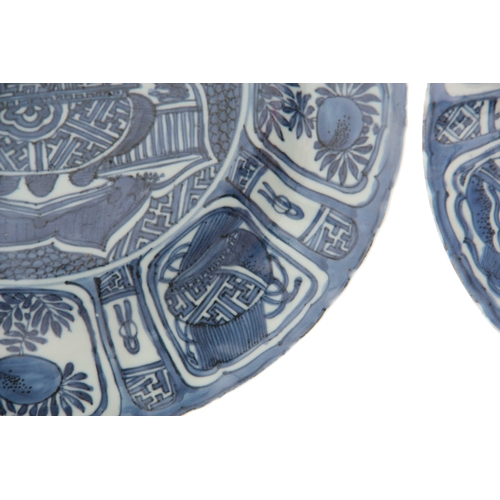 152 - A PAIR OF 17TH CENTURY CHINESE BLUE AND WHITE DISHES decorated with panels of flowers and antiquitie... 