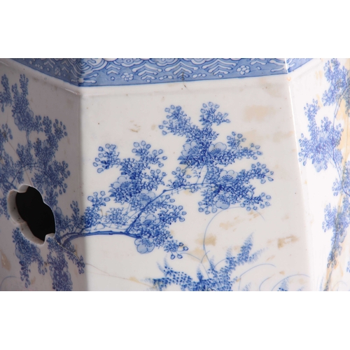 159 - A CHINESE BLUE AND WHITE HEXOGANOL GARDEN SEAT with leaf and flower head decorated top above a tree-... 