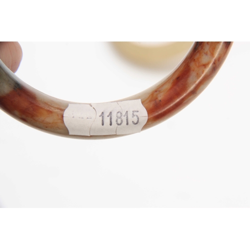 197 - THREE CHINESE RUST JADE BANGLES 92mm, 93mm and 90mm diameter overall.