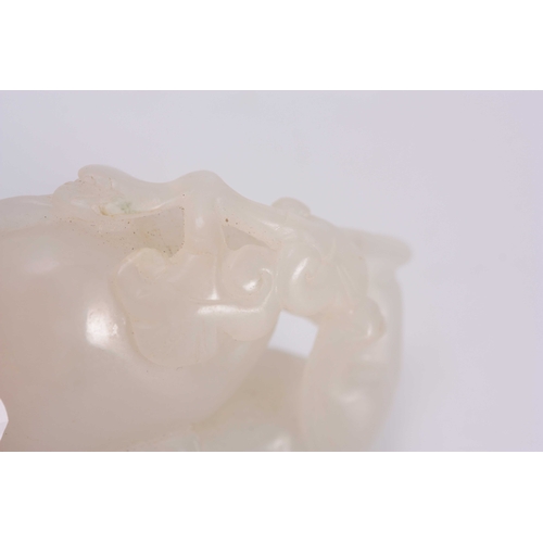 199 - A CHINESE CARVED WHITE JADE SCULPTURE depicting a Leopard climbing a rock 6cm overall 3cm wide.