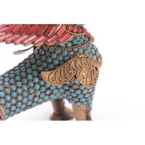 207 - AN ORIENTAL GILT BRASS BUDHISTIC DRAGON LION with jewelled coral coloured and turquoise decoration s... 