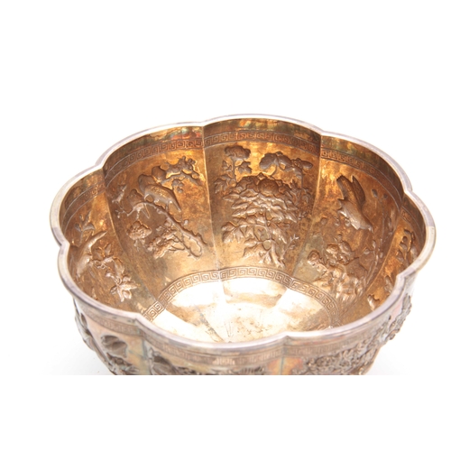 211 - A LARGE CHINESE SILVER BOWL with gilt interior having embossed foliate panels depicting birds, butte... 