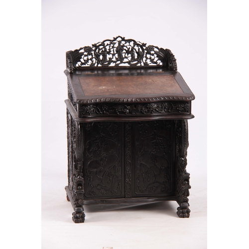 224 - A 19TH CENTURY CARVED HARDWOOD DAVENPORT with carved figural gallery above an angled leather writing... 