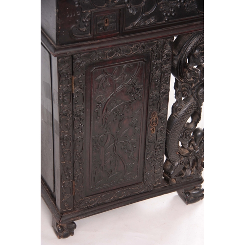 224 - A 19TH CENTURY CARVED HARDWOOD DAVENPORT with carved figural gallery above an angled leather writing... 