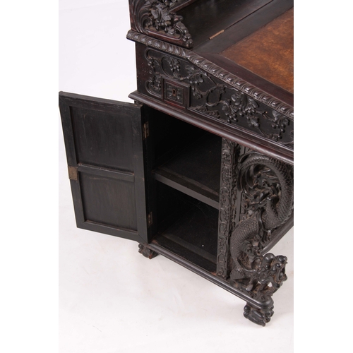 224 - A 19TH CENTURY CARVED HARDWOOD DAVENPORT with carved figural gallery above an angled leather writing... 