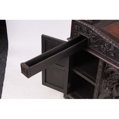 224 - A 19TH CENTURY CARVED HARDWOOD DAVENPORT with carved figural gallery above an angled leather writing... 