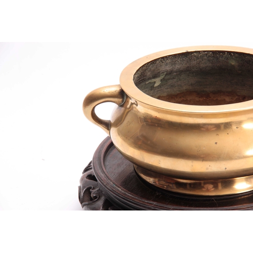 239 - AN EARLY CHINESE CAST BRASS CENSER of squat form with side handles, having a crest underneath - moun... 