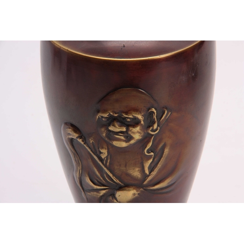 246 - A JAPANESE MEIJI PERIOD BRONZE VASE with relief moulded portrait of a Buddha 25cm high.