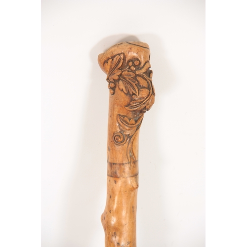 284 - A LATE 19TH CENTURY TAPERING KNOTCHED WALKING STICK with leaf and berry carved knop handle 90cm over... 