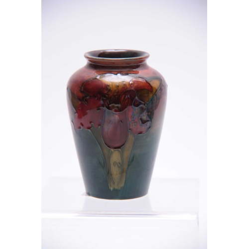 33 - A SMALL 20TH CENTURY FLAMBE MOORCROFT VASE decorated with orchids 9cm high.