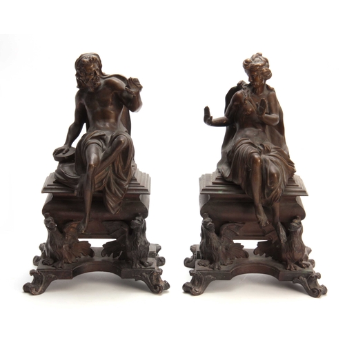 332 - A PAIR OF 19TH CENTURY CAST BRASS CHENET / FIREDOGS depicting a seated couple warming there hands mo... 