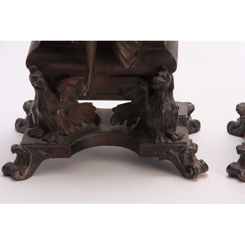 332 - A PAIR OF 19TH CENTURY CAST BRASS CHENET / FIREDOGS depicting a seated couple warming there hands mo... 