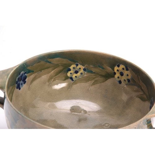 39 - A WILLIAM MOORCROFT BURSLEM FOOTED TWO-HANDLED BOWL with flowerhead and leaf spray decoration on a s... 