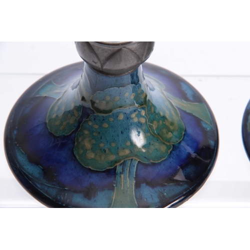 59 - A PAIR OF MOORCROFT MOONLIT BLUE TAPERING CIRCULAR BASE CANDLESTICKS WITH TUDIC PEWTER SCONCES 10cm ... 