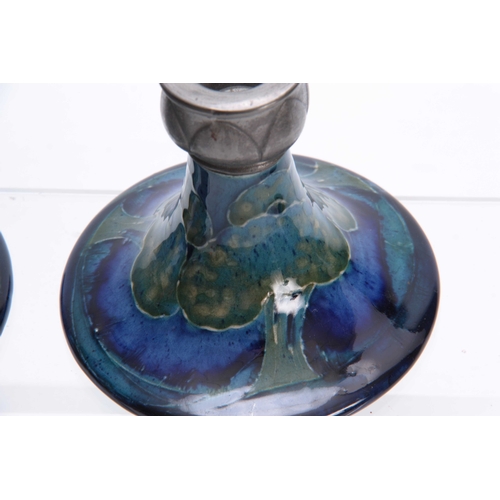 59 - A PAIR OF MOORCROFT MOONLIT BLUE TAPERING CIRCULAR BASE CANDLESTICKS WITH TUDIC PEWTER SCONCES 10cm ... 