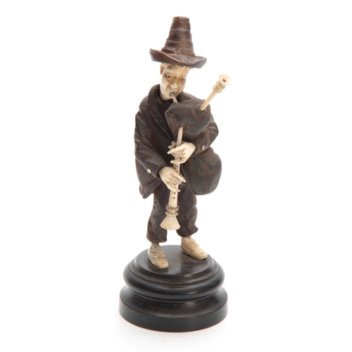 357 - A BLACK FOREST BONE AND CARVED WOOD STANDING MALE FIGURE OF A TYROLEAN MUSICIAN on circular base 17c... 