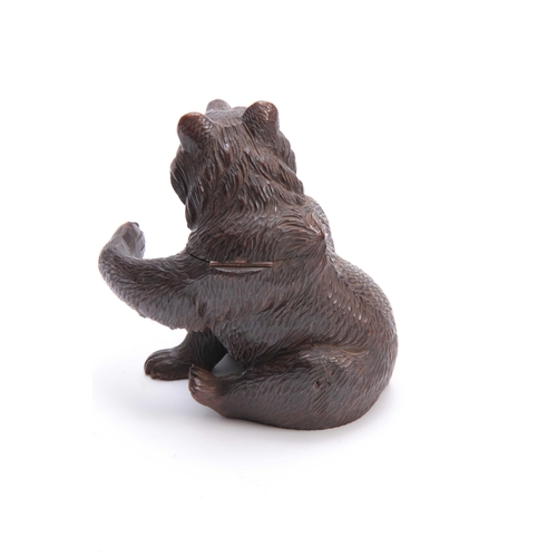 367 - A 19TH CENTURY SWISS CARVED BLACK FOREST SEATED BEAR INKWELL with hinged lid and arm outstretched fo... 