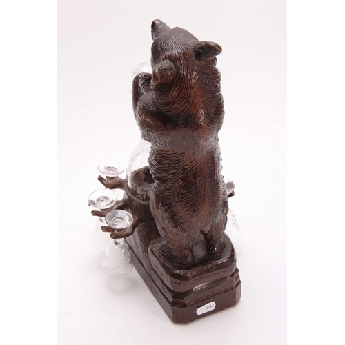 370 - AN EARLY 20th CENTURY CARVED BLACK FOREST MUSICAL DECANTER STAND modelled as a standing bear beside ... 