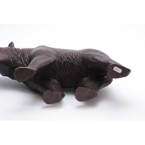 374 - A LATE 19TH CENTURY SWISS BLACK FOREST CARVED BEAR with glass eyes 46cm wide.