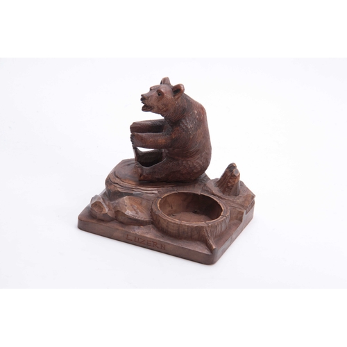 375 - A LATE 19TH CENTURY SWISS BLACK FOREST CARVED BEAR PIPE STAND  depicting a seated bear on a naturali... 