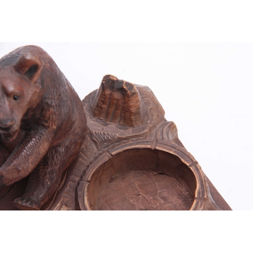 375 - A LATE 19TH CENTURY SWISS BLACK FOREST CARVED BEAR PIPE STAND  depicting a seated bear on a naturali... 