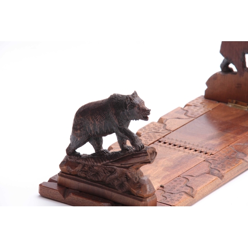 376 - A LATE 19TH CENTURY SWISS BLACK FOREST CARVED ADJUSTABLE BOOKREST with bears to each side on natural... 